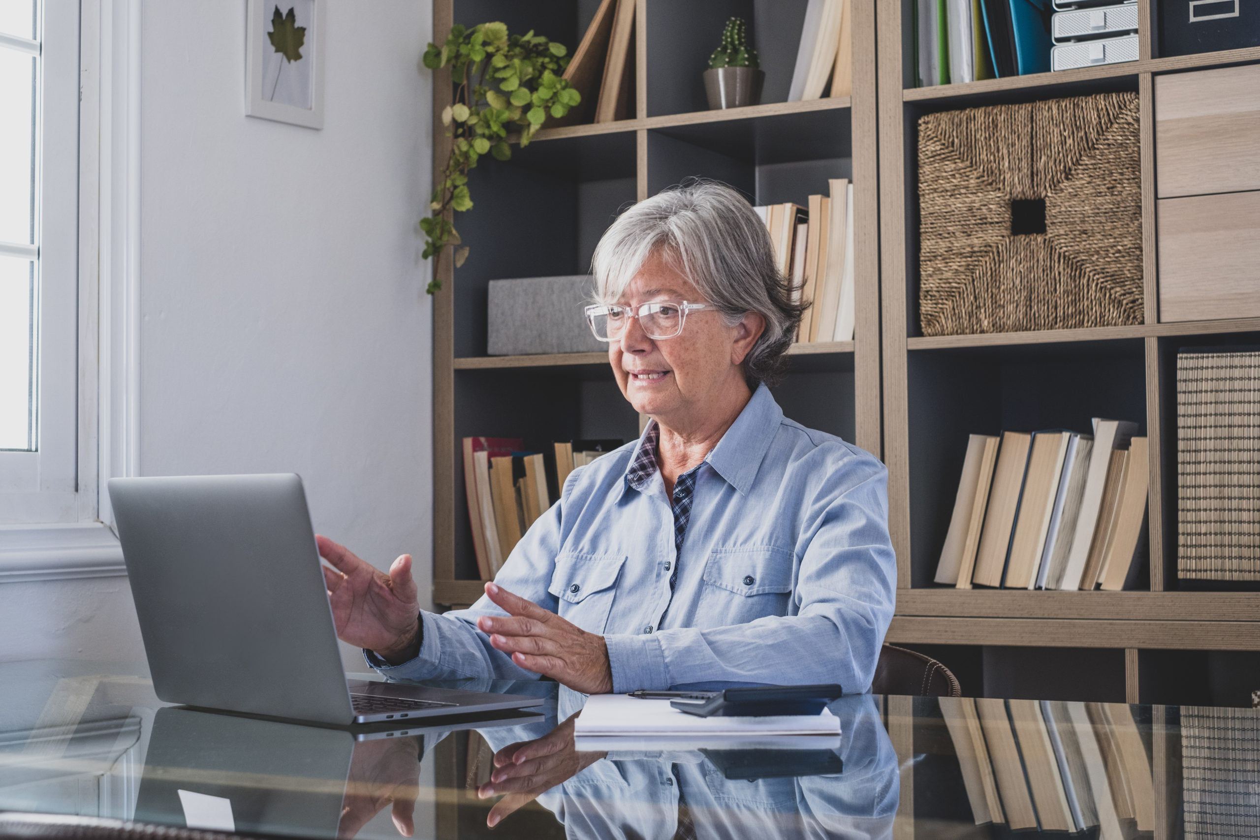 Happy old caucasian businesswoman smiling working online watchin